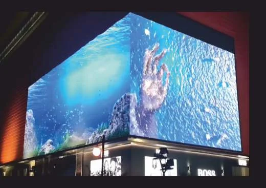 Corner LED video wall on a building showing a 3D wave effect